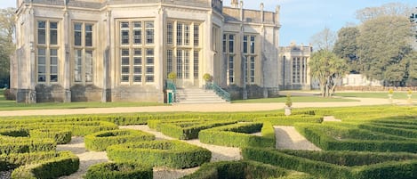 A historic building with a symmetrical facade, large windows, and a central staircase leading to the entrance.