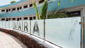 Un edificio moderno con fachada curva, amplias ventanas y un llamativo letrero 'NARA'.