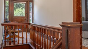 Un escalier en bois avec une rampe, menant à l’étage supérieur.