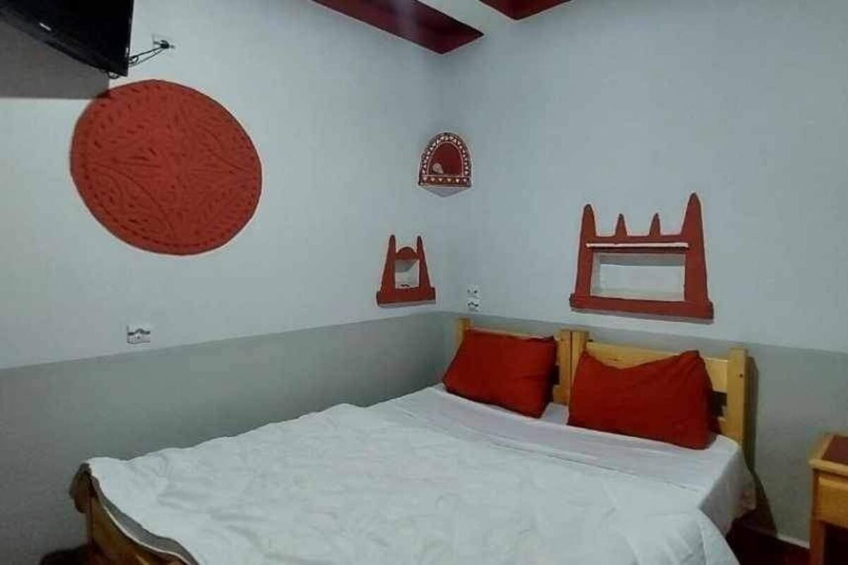 Une chambre à coucher comprenant un lit, deux tables de chevet et des éléments décoratifs sur les murs.