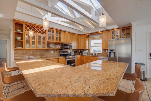 A modern kitchen with granite countertops, stainless steel appliances, and wooden cabinetry.