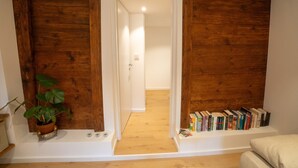 A room with wooden paneling, a potted plant, and a bookshelf. - Urlaub auf dem Bartleshof (Unterkirnach)