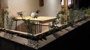 An outdoor dining area with a wooden table and chairs, surrounded by potted plants and flowers. - Urlaub auf dem Bartleshof (Unterkirnach)