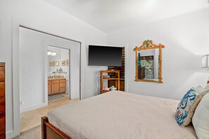 Ein Schlafzimmer mit einem Bett, einem Fernseher, einem Spiegel und einem Kleiderschrank.