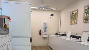 A laundry facility with a ceiling fan, a soap center, and a fire extinguisher.