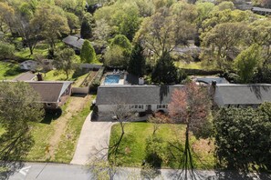 Vue aérienne d’un quartier résidentiel avec des maisons, une piscine et une pelouse bien entretenue.