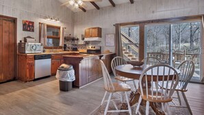 A spacious kitchen with wooden cabinets, a large island, and a dining area with white chairs.