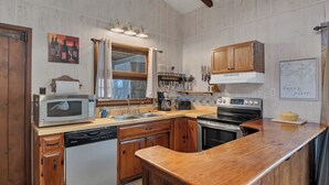 A kitchen with wooden cabinets, a microwave, a dishwasher, a stove, and a sink.