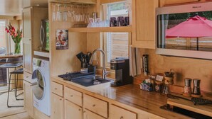 Une cuisine compacte avec des meubles en bois, un four encastré et un four à micro-ondes.