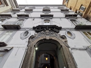 A building facade with ornate architectural details, including a central archway and multiple balconies. - Casa centro storico di Napoli a pochi passi da Metro, Stazione Centrale e Porto (Napoli)