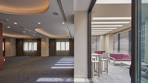 A spacious room with patterned carpet, recessed lighting, and a large window with blinds. - M Suite Hotel (Algiers)