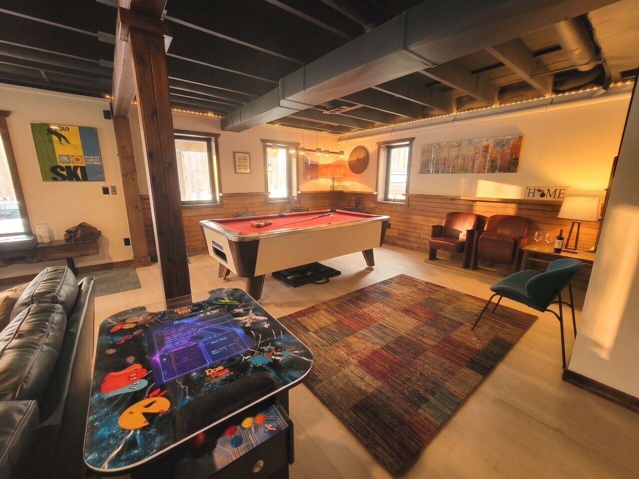 Ein gemütliches Wohnzimmer mit Billardtisch, Kicker und einer bequemen Sitzecke.
