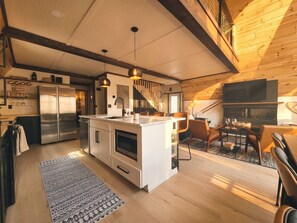 A modern kitchen with a central island, stainless steel appliances, and pendant lighting.