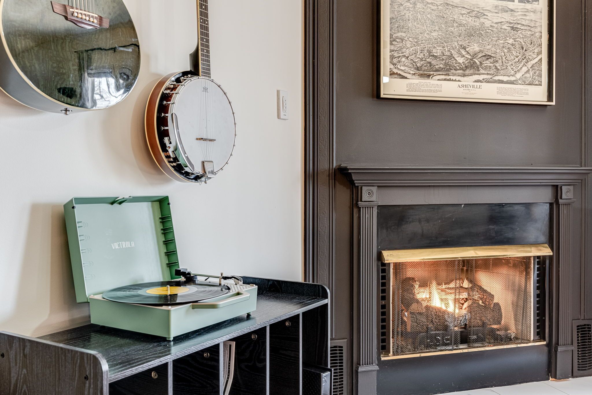 Una habitación con un tocadiscos, un banjo y una chimenea.