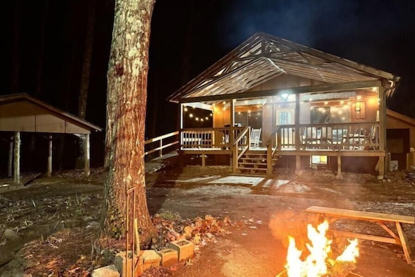 Fire pit with seating area in front of cabin.