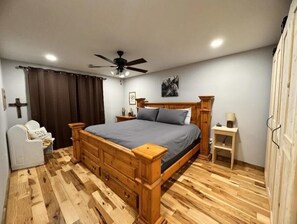 Relax in this serene bedroom with a large bed, nightstand, and comfortable seating area.
