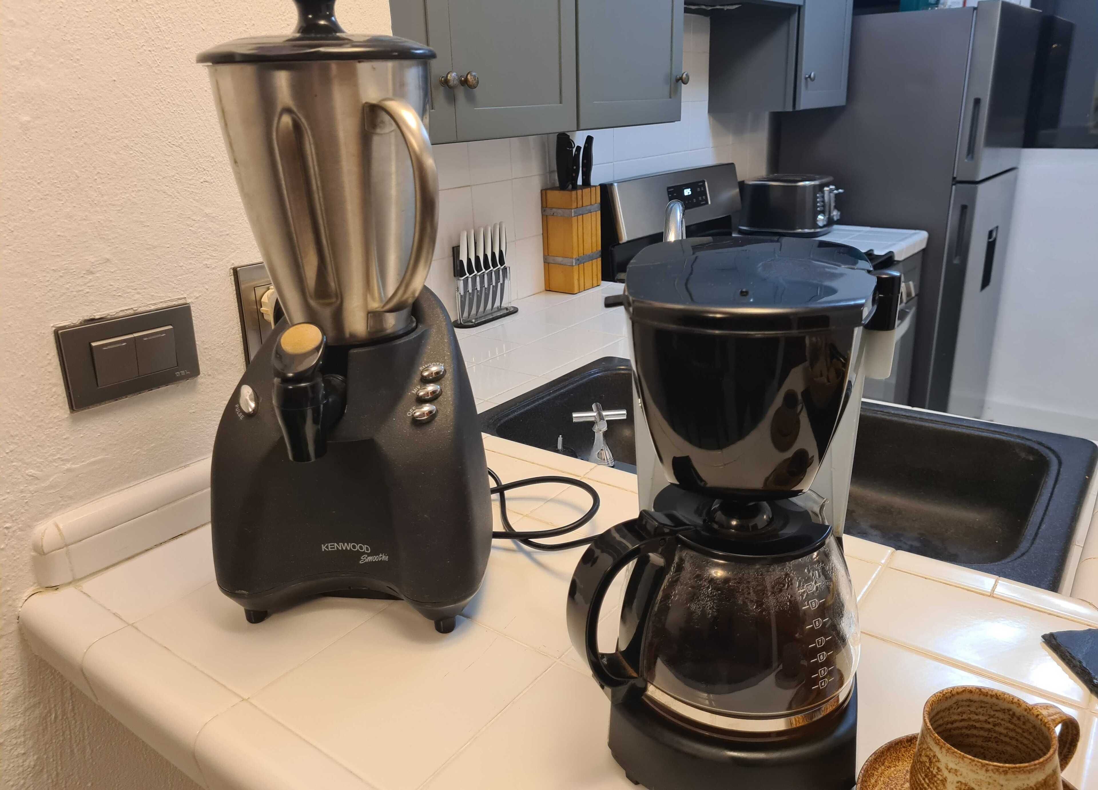 Uma cozinha com um mixer Kenwood e uma cafeteira sobre a bancada.