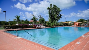 A swimming pool with clear blue water, surrounded by a tiled deck and lounge chairs. - Wild Lotus Villa - Waterfront on Jolly Harbour (Jolly Harbour)