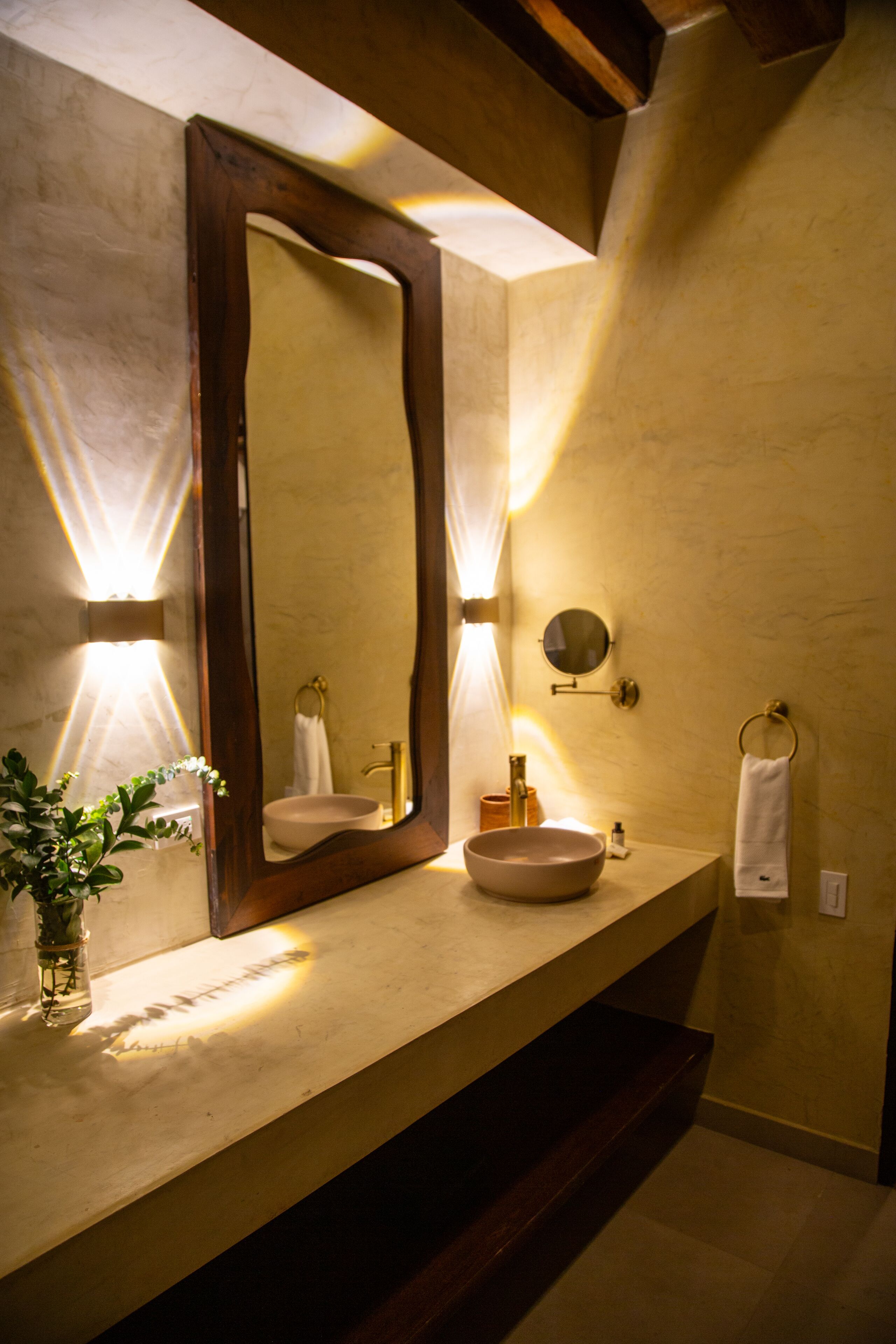 A bathroom with a large mirror, a vessel sink, and a towel rack.