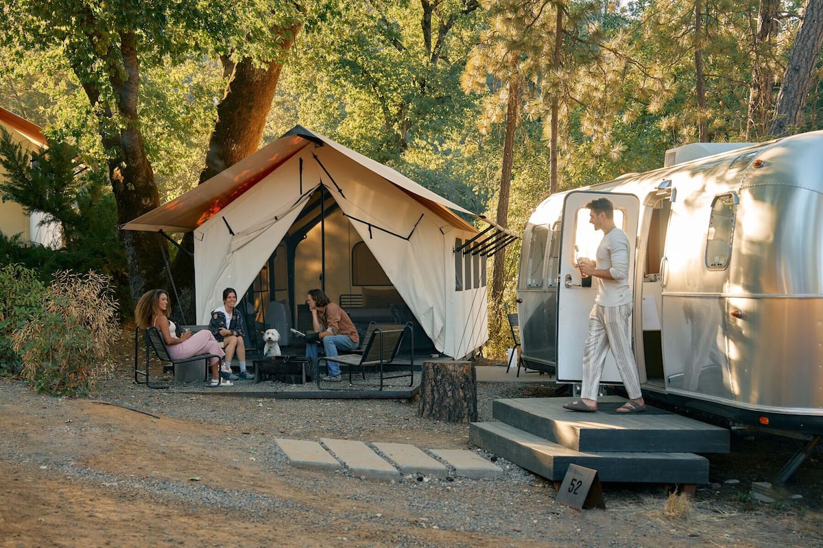 Un camping con una tienda de campaña y una caravana.