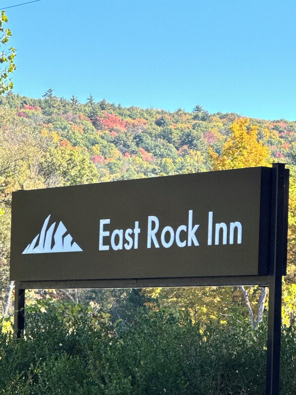 A sign for East Rock Inn with a mountain graphic. - East Rock Inn (Great Barrington)