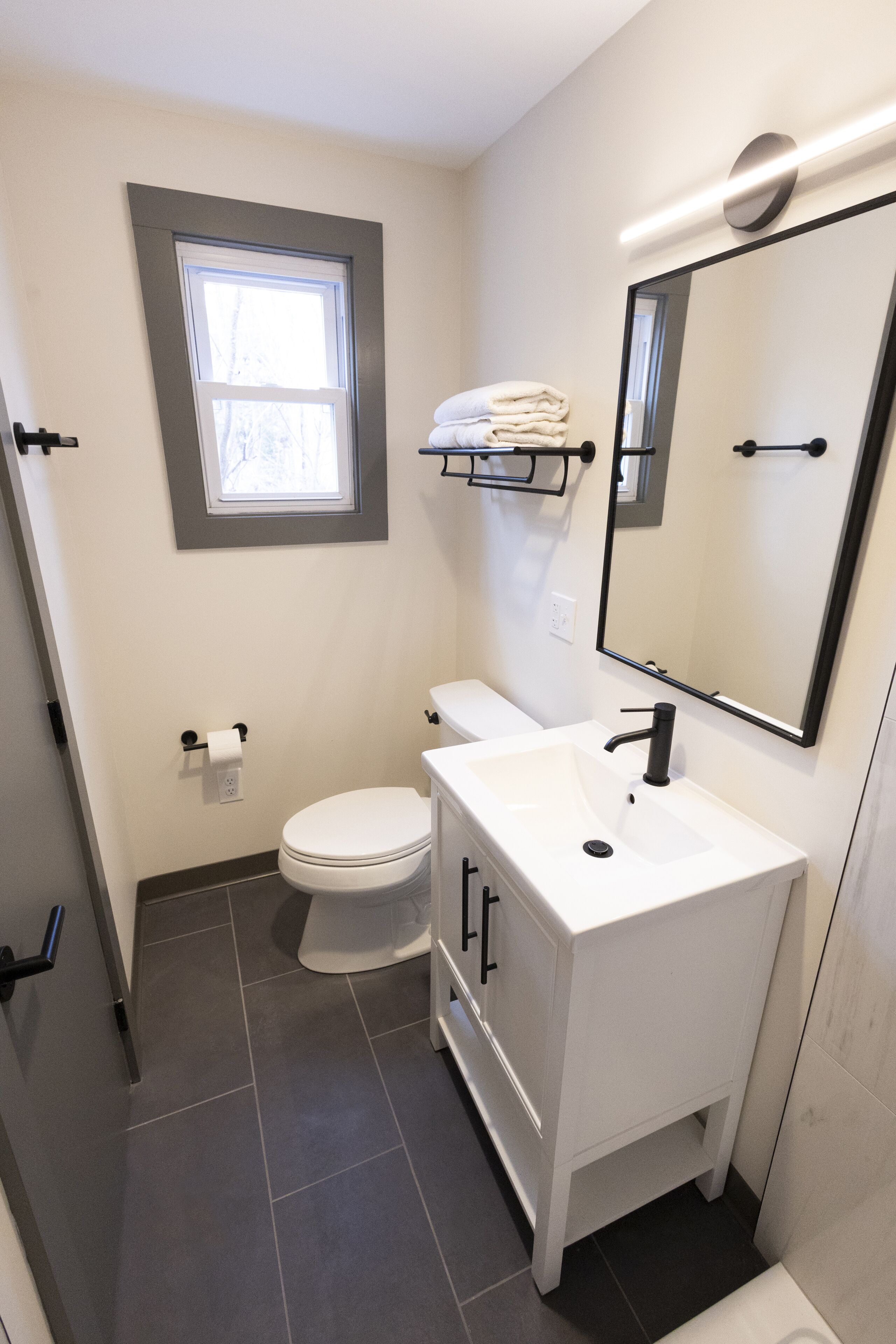 Une petite salle de bain comprenant des toilettes, un lavabo et un miroir.