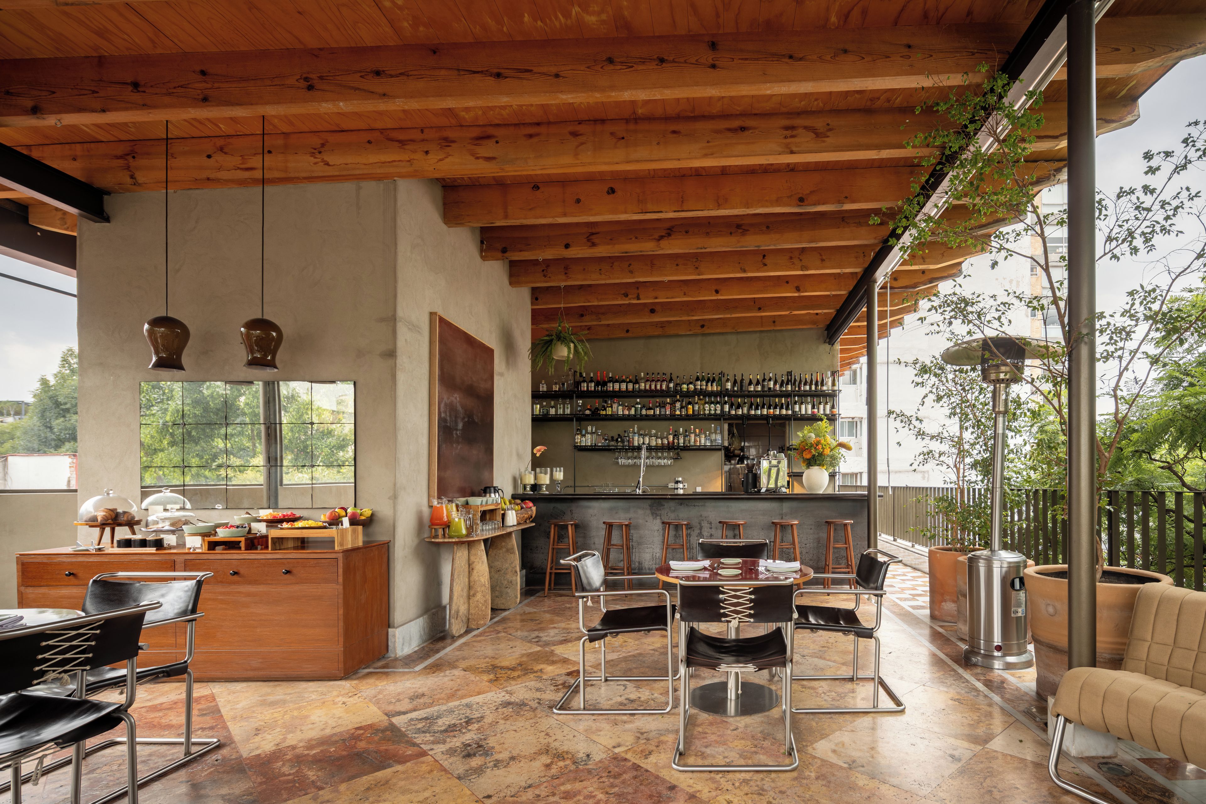 A spacious kitchen with a bar area, wooden ceiling beams, and a view of the outdoors.