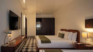 A hotel room with a checkered floor, a bed with pillows, a bedside table with a lamp, a mirror, and a television.