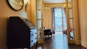 A hallway with a grand piano, a mirror, and a chandelier. - GRAN HOTEL BOLIVAR (Lima)