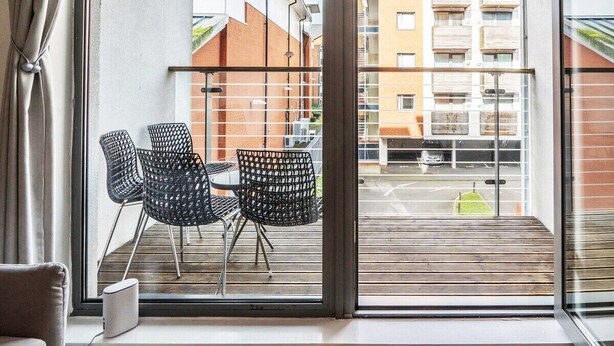 A balcony with two black wicker chairs and a white device on the windowsill. - Aspire City Centre Suite - PingPong & Netflix (West Midlands)