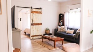 A living room with a sofa, a coffee table, a sliding door, and a bookshelf.
