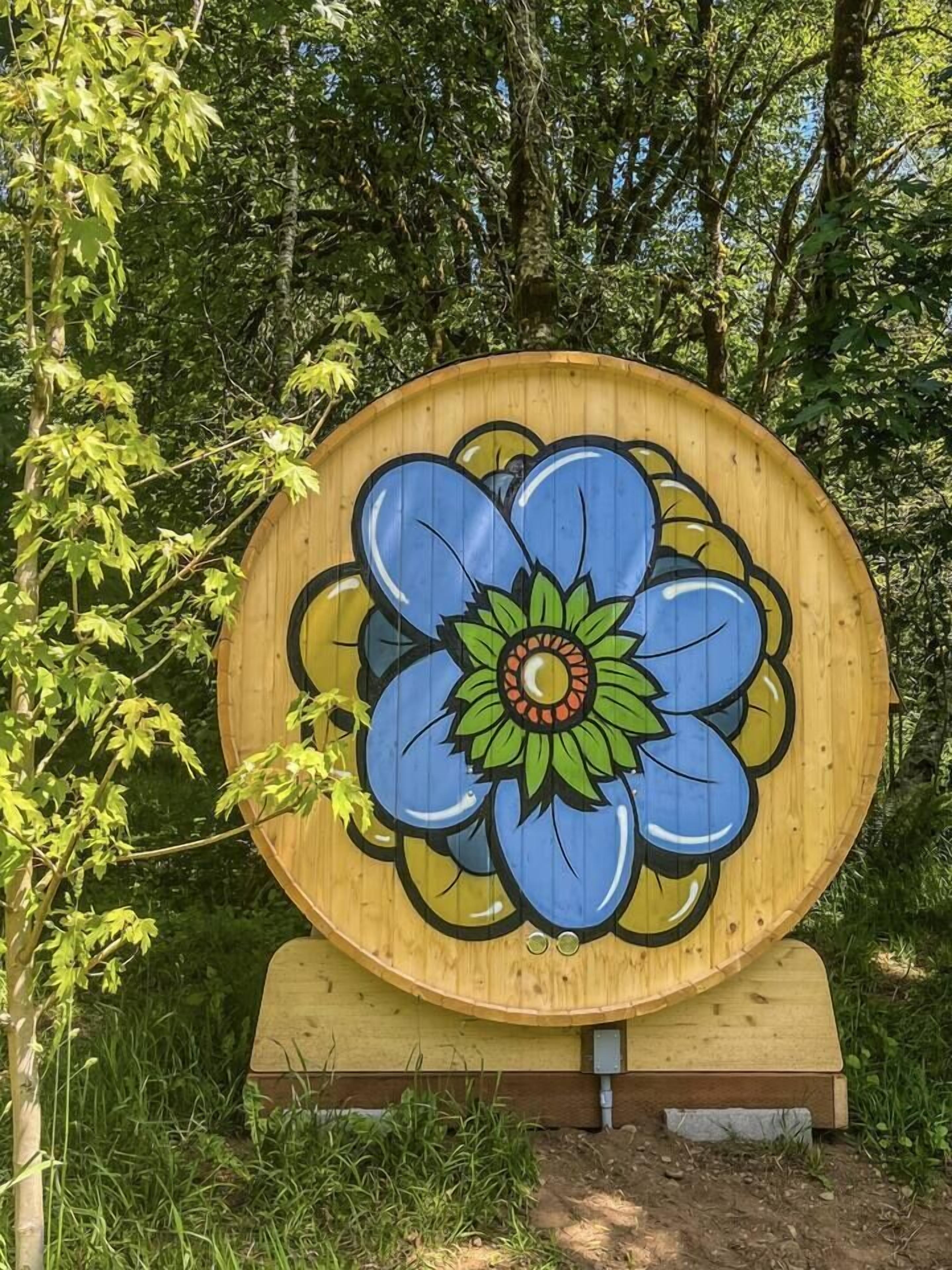 A large wooden sign with a painted flower design.
