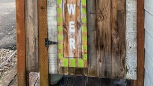 A wooden gate with a sign that reads "SHOWER."