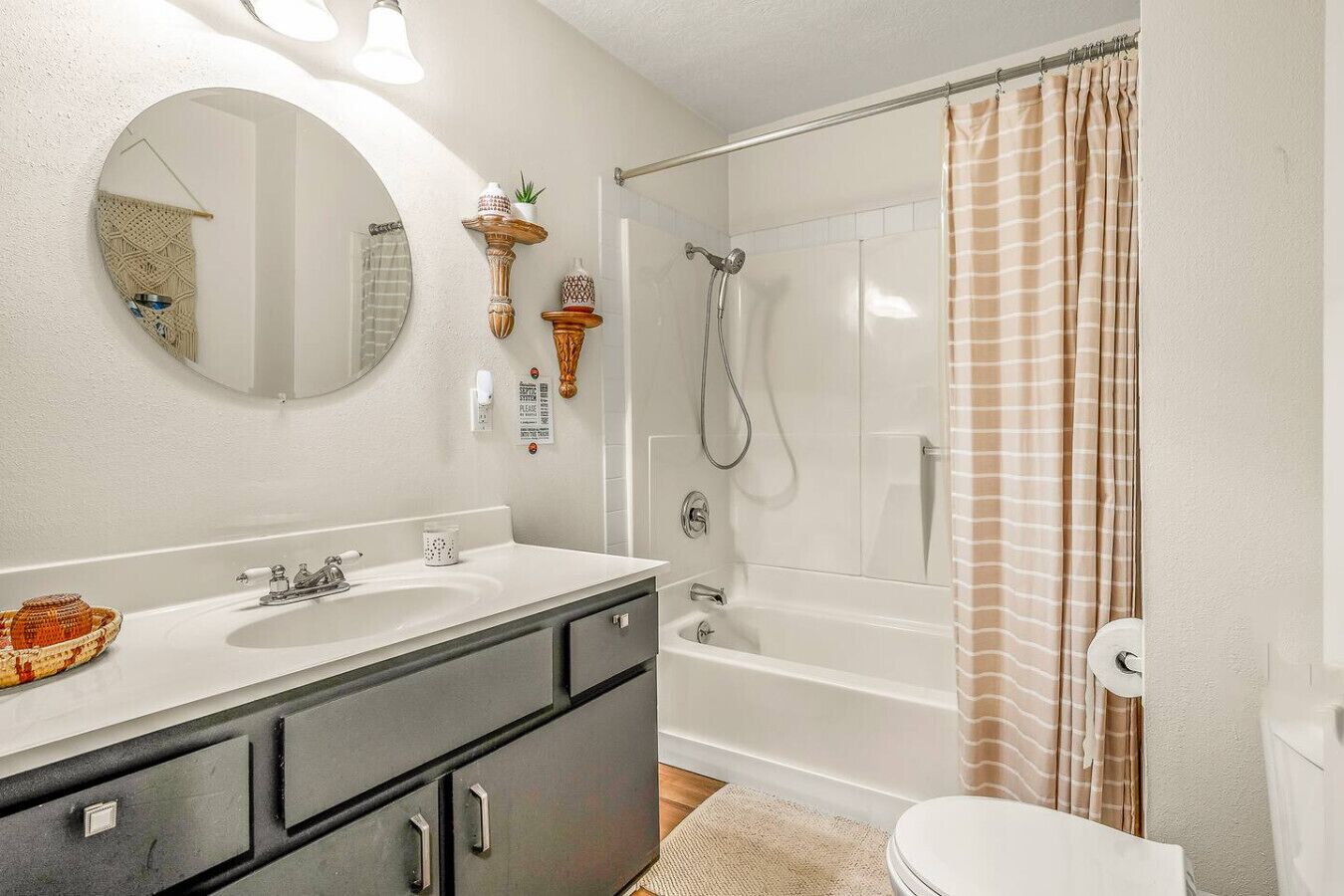 Ein Badezimmer mit Badewanne, Dusche, Waschbecken, Spiegel und Toilette.
