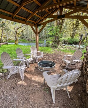 Un espace extérieur aménagé avec des chaises Adirondack et un foyer.