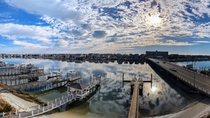 A marina with docks and a bridge connecting to a cityscape. - Harbor Inn (Wrightsville Beach)