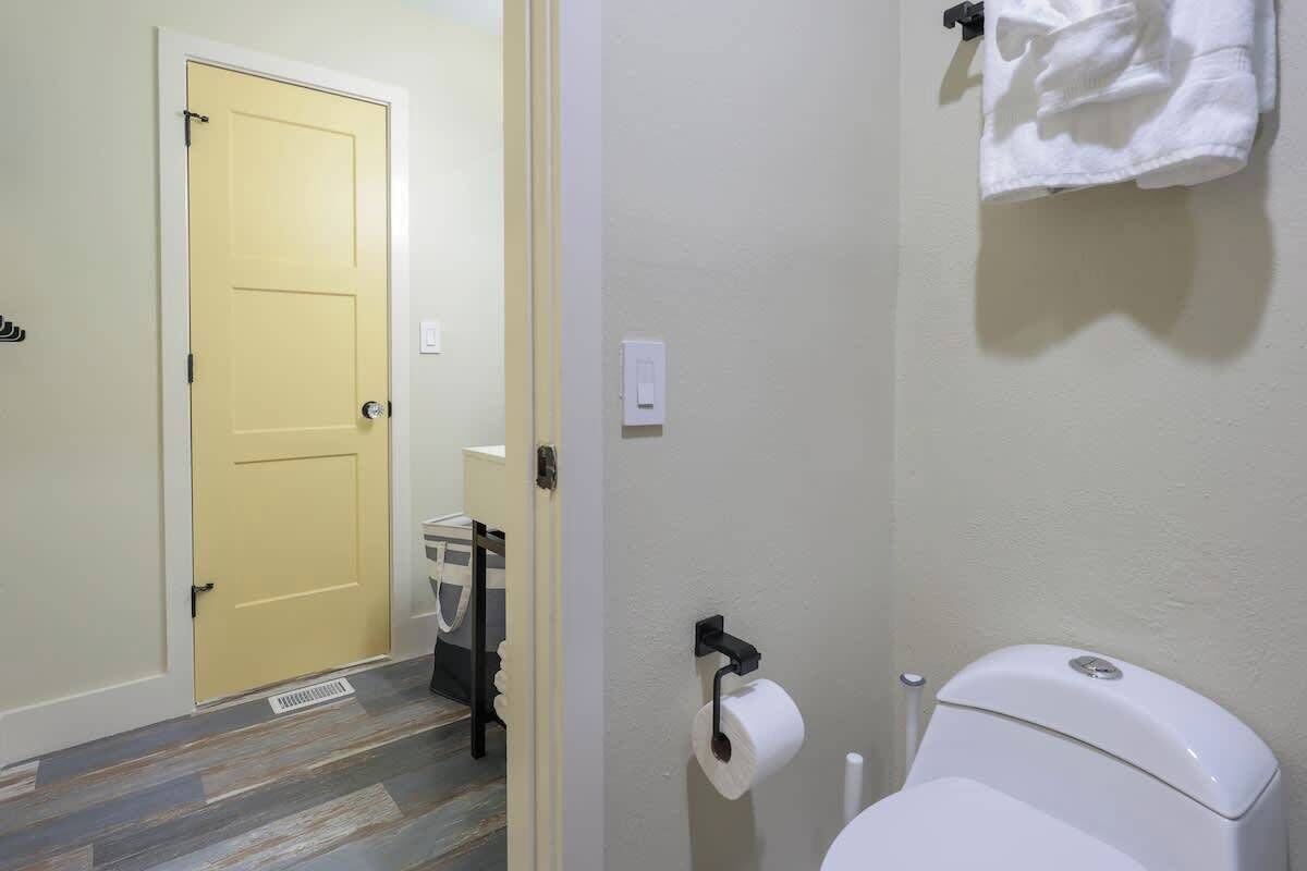 A bathroom with a toilet, a towel rack, and a door.