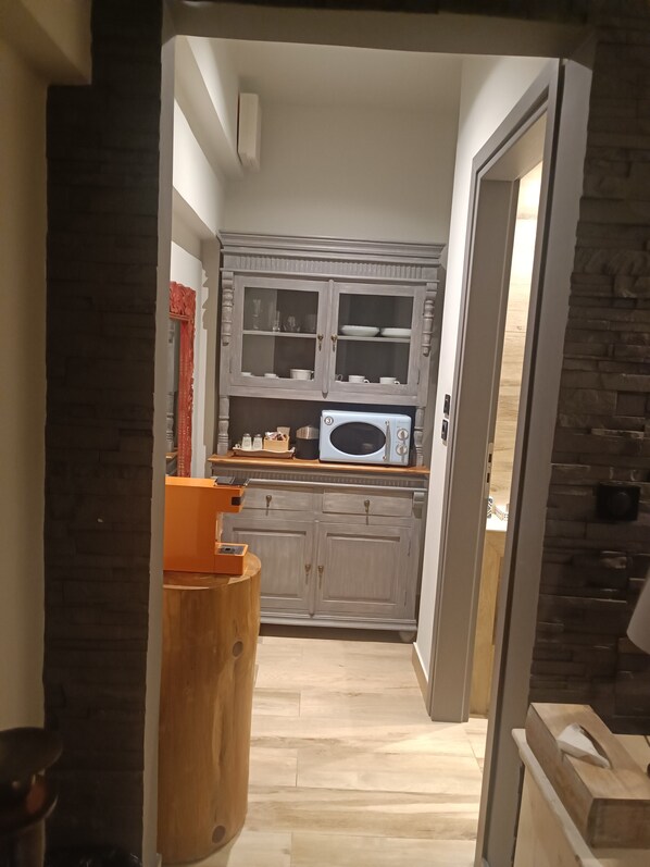 A kitchen with grey cabinets, a microwave, and a wooden counter. - Aval Riviera (Saronikos)