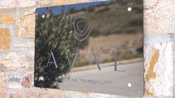 A metal plaque with the text "AVAL RESTORING TRANQUILLITY" mounted on a stone wall.