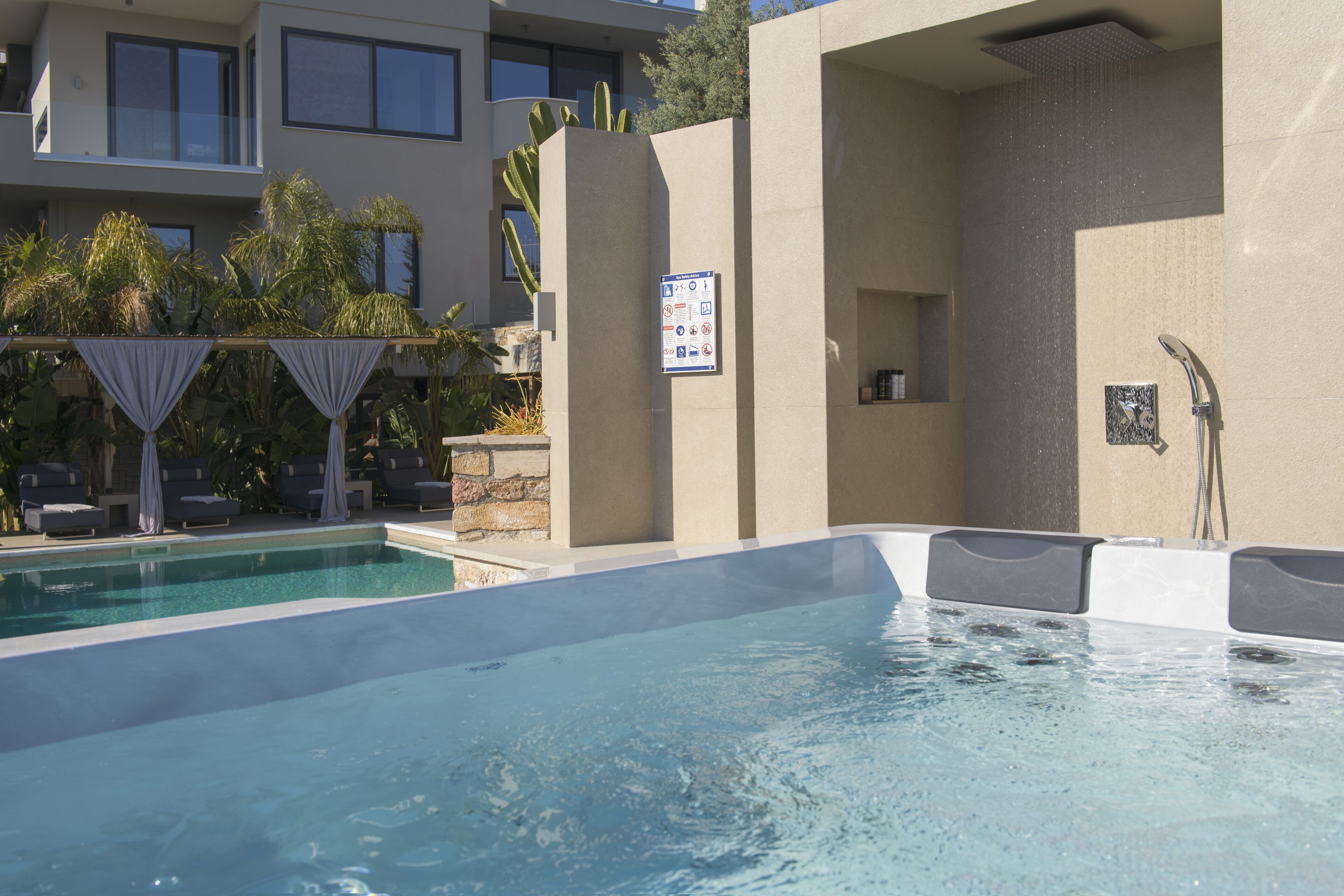 A swimming pool area with lounge chairs and a hot tub.
