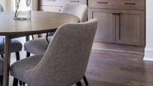 A modern kitchen with grey tiled backsplash, wooden cabinets, and a dining area with a table and chairs. - 2 West End Homes with Stunning Rooftop Views (Nashville)