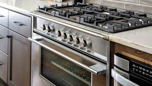 A modern kitchen with stainless steel appliances, wooden cabinets, and a tiled backsplash. - 2 West End Homes with Stunning Rooftop Views (Nashville)