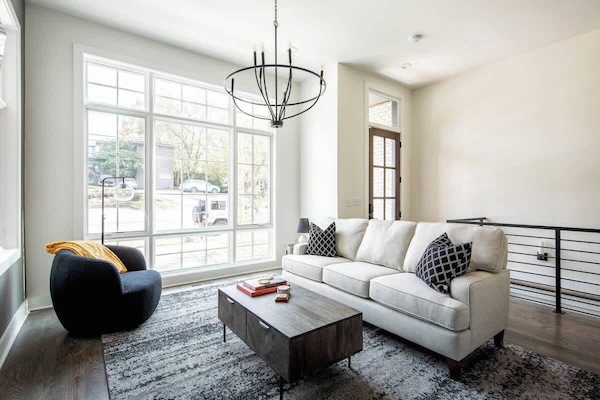 Relax in a luminous living room with a large window and comfy white sofa.