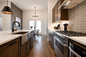 A modern kitchen with a central island, stainless steel appliances, and a pendant light.
