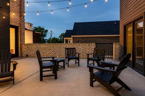 Un espace extérieur aménagé en terrasse, avec des sièges et des guirlandes lumineuses.