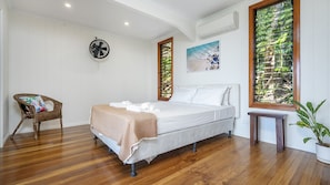 A bedroom with a bed, a chair, a small table, and a potted plant. - Stu’s Lookout - Stunning Views (Wongaling Beach)