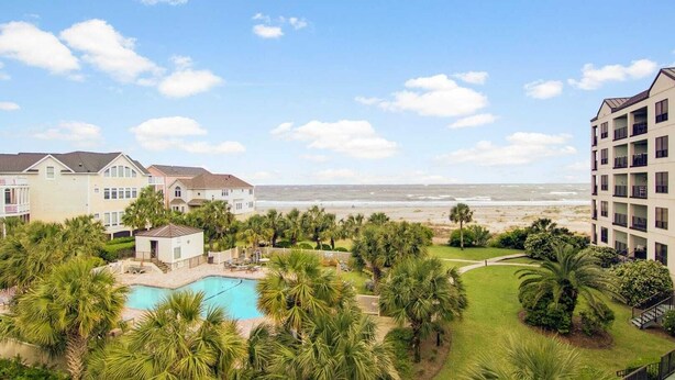 A resort with a pool, palm trees, and a view of the beach. - 311 Summerhouse by Avantstay Beach Views Access to Community Pool (Isle of Palms)
