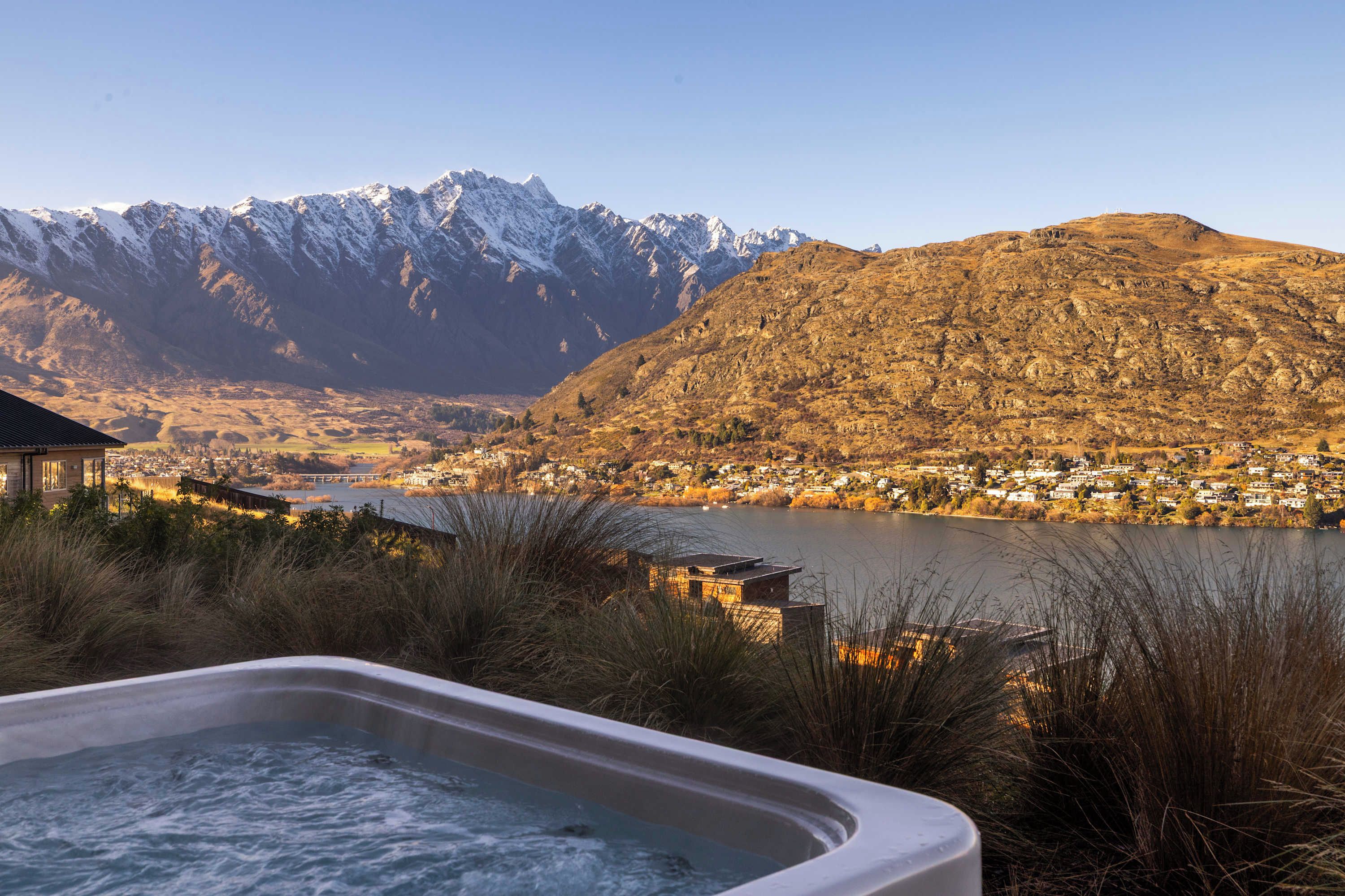 A hot tub with a view of a lake and mountains.