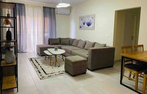 Appartement Confort, balcon, vue établissement | Coin séjour | TV connectée de 55 pouces avec chaînes thématiques