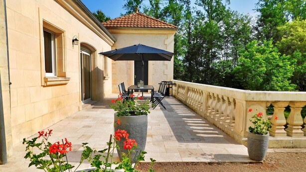 A patio with outdoor furniture, a covered seating area, and potted plants. - Le Moulin De Lombraud (Brantome En Perigord)